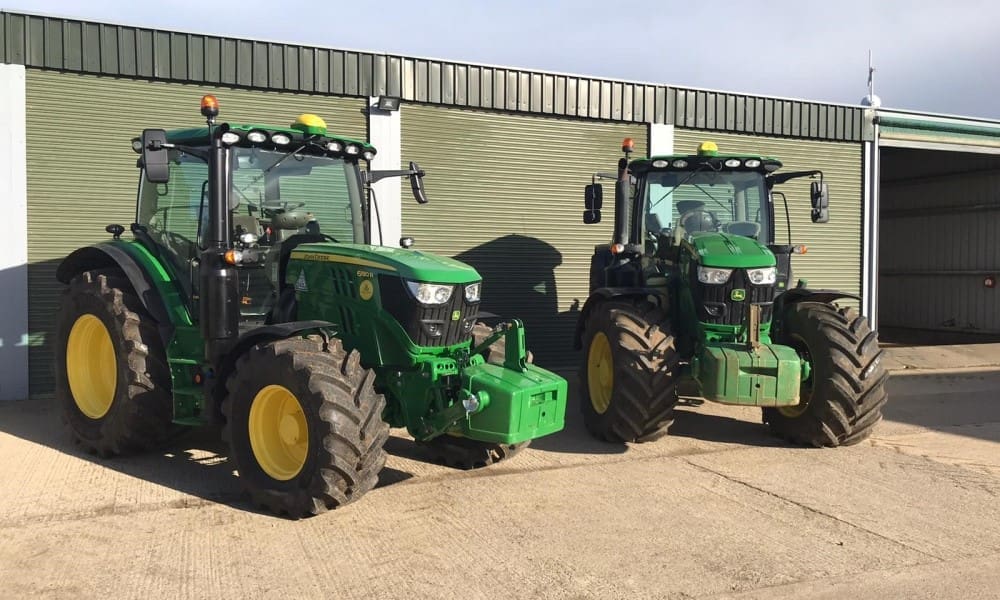 Two green tractors parked side by side in front of a shed on a training site for RIIMPO315E Conduct Tractor Operations practical training