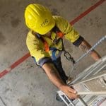 RIIWHS204E Work Safely at Heights — personnel using fall protection on an elevated structure.