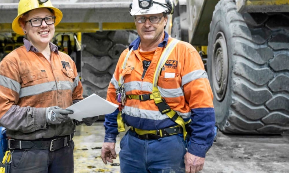 Mining workers wearing hard hats and high‑visibility safety gear at a surface mine site during Standard 11 Surface Mining induction training.