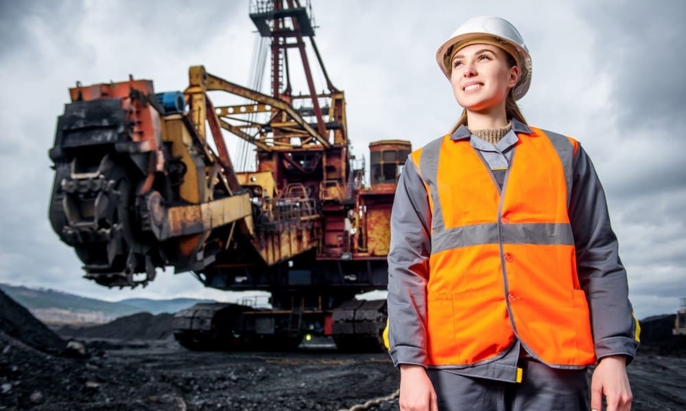 Photo showing a mining site induction session with workers wearing high‑visibility safety gear and hard hats, participating in Standard 11 surface mining training.